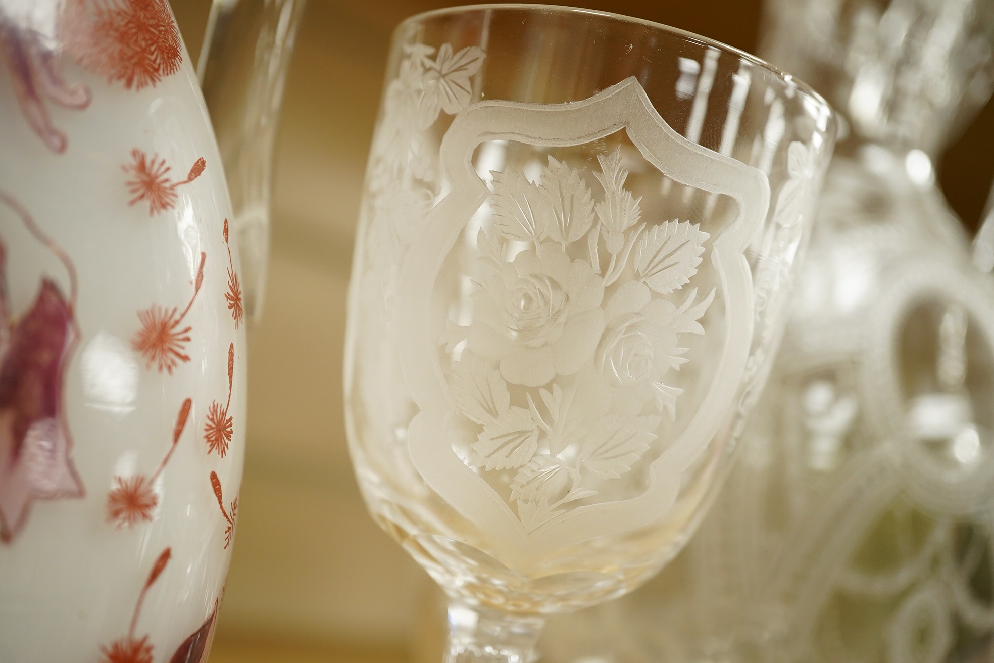 A Continental Art Nouveau glass carafe enamelled with flowers, an English wine glass engraved with the symbols of the Union, a Victorian engraved claret jug and a toddy lifter. Condition - carafe has some occasional scra